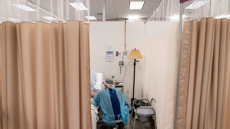 A physical therapist works with a patient at a field hospital operated by Care New England set...