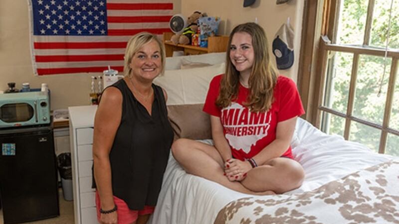 Laura Bowling poses with her daughter Sarah Bowling in the dorm room she lived in 33 years ago.