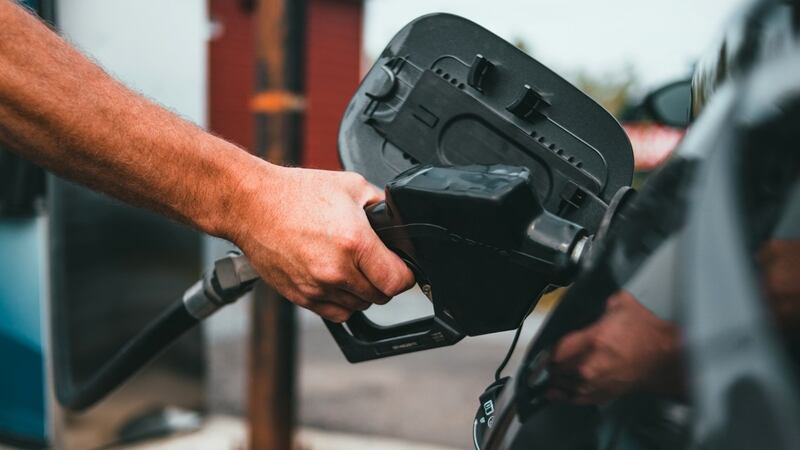 FILE - A customer pumps fuel at a gas station.